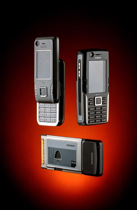 3 mobile phones suspended on an amber background